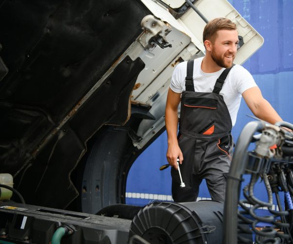 Professional truck mechanic working in vehicle repair service.