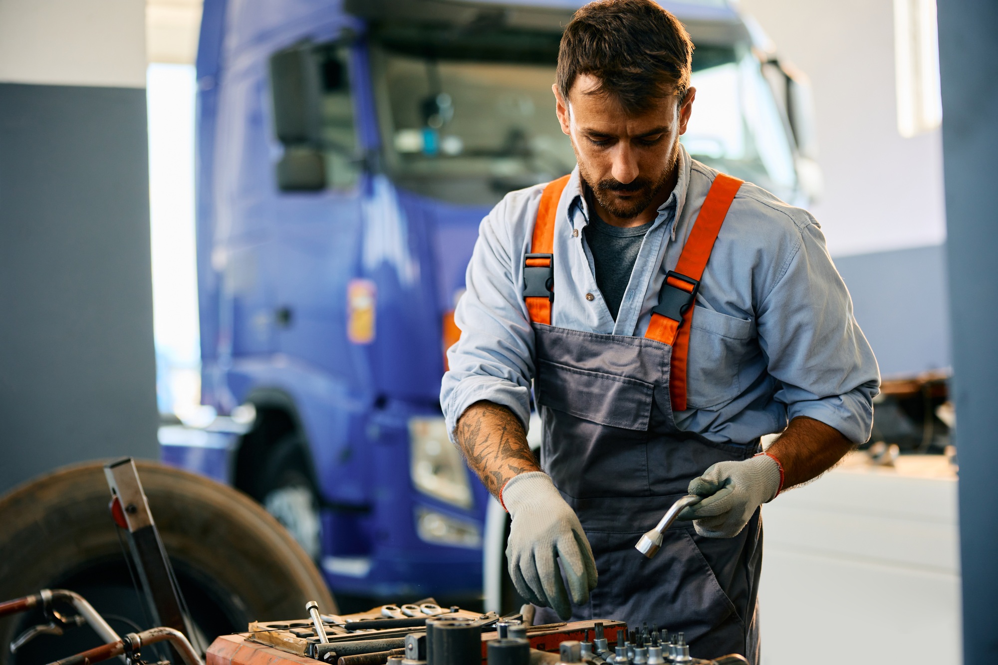 Mid adult mechanic working at truck repair shop.